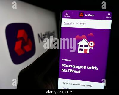 Stuttgart, Allemagne, 11-22-2023 : personne tenant un smartphone avec la page web de la société financière National Westminster Bank (NatWest) avec le logo. Concentrez-vous sur Banque D'Images