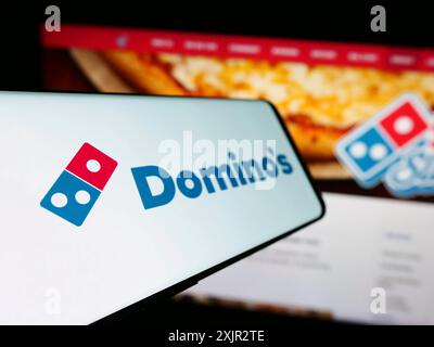 Stuttgart, Allemagne, 12-09-2023 : smartphone avec le logo de la chaîne de restaurants américaine Domino's Pizza Inc en face du site Web de l'entreprise. Concentrez-vous sur Banque D'Images