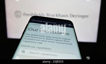 Stuttgart, Allemagne, 12-17-2023 : smartphone avec le site Web du cabinet d'avocats britannique Freshfields Bruckhaus Deringer LLP devant le logo de l'entreprise. Concentrez-vous sur Banque D'Images