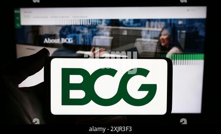 Stuttgart, Allemagne, 12-20-2023 : personne tenant un smartphone avec le logo de la société américaine Boston Consulting Group Inc (BCG) devant le site Web. Concentrez-vous sur Banque D'Images