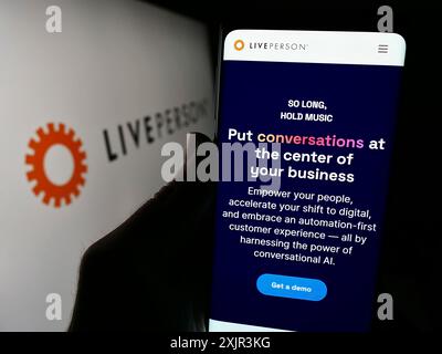 Stuttgart, Allemagne, 12-20-2023 : personne tenant un smartphone avec la page web de la société de commerce conversationnel LivePerson Inc devant le logo. Concentrez-vous sur Banque D'Images