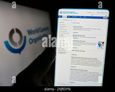 Stuttgart (Allemagne), 12 28 2023 : personne tenant un téléphone portable avec la page Web de l'Organisation mondiale des douanes (OMD) devant le logo. Concentrez-vous sur le centre du téléphone Banque D'Images