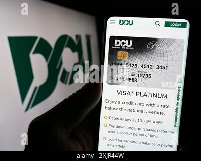 Stuttgart, Allemagne, 02-06-2024 : personne tenant un smartphone avec la page web de l'institution financière Digital Federal Credit Union (DCU) avec le logo. Mise au point Banque D'Images