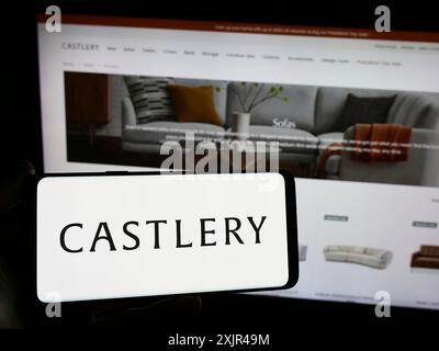 Stuttgart, Allemagne, 02-07-2023 : personne tenant un smartphone avec le logo de la société singapourienne de commerce électronique de meubles Castlery en face du site Web. Mise au point Banque D'Images