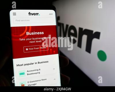 Stuttgart, Allemagne, 02-11-2024 : personne tenant un smartphone avec la page web de la société de plate-forme freelance Fiverr International Ltd avec logo. Concentrez-vous sur Banque D'Images