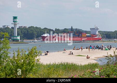 Navire porte-conteneurs, bateau à voile, phare Friedrichsort, personnes, plage, fjord de Kiel, Kiel, Schleswig-Holstein, Allemagne Banque D'Images