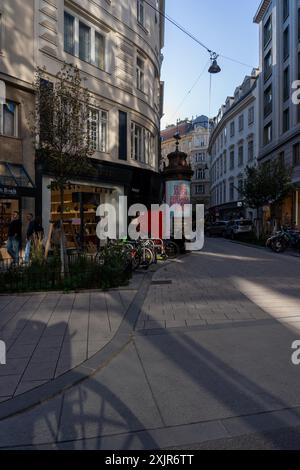 Wien, Autriche - 28 octobre 2023 : Une rue pavée à Vienne, Autriche, avec des vélos garés projetant de longues ombres sur le trottoir. La rue est Line Banque D'Images