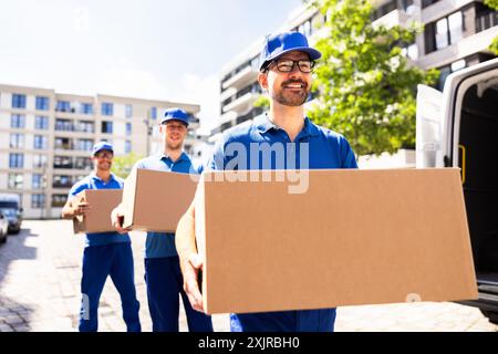 Hommes qui travaillent dur à la livraison transportant des boîtes en carton dans la fourgonnette - coursiers efficaces pour le service de logistique de la chaîne d'approvisionnement des entreprises locales. Banque D'Images