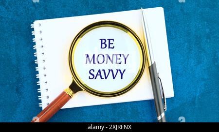 Concept d'affaires à propos de Be Money Savvy avec inscription à travers une loupe sur un morceau de bloc-notes Banque D'Images
