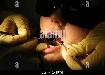 Dossier photo datée du 19/05/11 d'un dentiste au travail. Les dentistes ont mis en garde les ministres écossais contre la complaisance malgré les progrès «bienvenus» sur la réforme des paiements. Un programme introduit en novembre signifie que les dentistes qui dispensent des traitements du NHS reçoivent une augmentation des honoraires. Les bilans restent gratuits pour tous les patients, les femmes enceintes et les nouvelles mères, les personnes qui demandent des prestations et les moins de 26 ans encore exemptés de frais. Date d'émission : samedi 20 juillet 2024. Banque D'Images