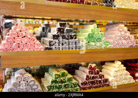 Divers délices turcs vibrants de différentes formes et couleurs sur des étagères en bois dans un magasin. Concept de friandises sucrées et confiseries Banque D'Images