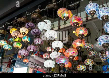 Lanternes en mosaïque turque vibrantes suspendues dans un magasin, présentant des motifs complexes et des couleurs vives. Concept de décoration traditionnelle Banque D'Images