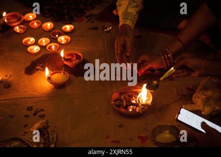 Les dévots allument des lampes à huile de terre à l'occasion de Dev Diwali au ghat de Varanasi. Banque D'Images