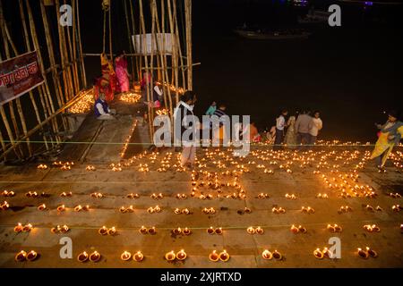 Les dévots allument des lampes à huile de terre à l'occasion de Dev Diwali au ghat de Varanasi. Banque D'Images