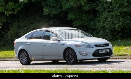 Milton Keynes, Royaume-Uni - 18 juillet 2024 : 2013 voiture blanche Ford Mondeo conduisant sur une route de campagne britannique Banque D'Images