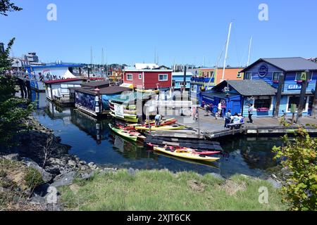 Victoria, Canada - 3 juillet 2023 : touristes explorant les bâtiments colorés du quai de Fisherman Banque D'Images