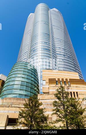 La tour Mori, avec le bâtiment d'entrée du musée d'art Mori en face, surplombant le spectateur dans un ciel bleu clair et un soleil éclatant. Roppongi Hills. Banque D'Images