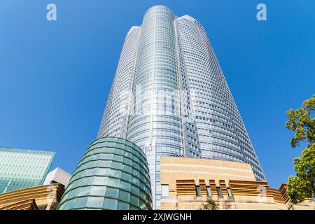 La tour Mori, avec le bâtiment d'entrée du musée d'art Mori en face, surplombant le spectateur dans un ciel bleu clair et un soleil éclatant. Roppongi Hills. Banque D'Images