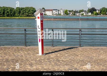 Une boîte d'appel d'urgence rouge et blanche se trouve près du Rhin à Neuwied, en Allemagne. La boîte d'appel a un récepteur téléphonique rouge et signe SOS et DLRG Banque D'Images