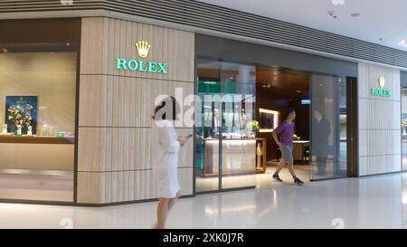 Shopper quitte la marque de montres suisses et le fabricant Rolex logo et magasin à Hong Kong, Chine Banque D'Images