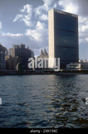 New York, États-Unis. Septembre 1959 : vue du siège de l'Organisation des Nations Unies (ONU) dans le quartier de Turtle Bay à Midtown Manhattan à New York, prise de l'East River. Achevé en 1952, le complexe a été conçu par un conseil d'architectes dirigé par Wallace Harrison et construit par le cabinet d'architectes Harrison & Abramovitz. Visible au loin est l'Hôtel Waldorf Astoria. Banque D'Images