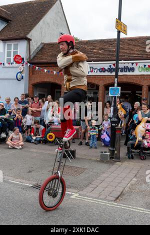 Overton Sheep Fair le 20 juillet 2024. L'événement quadriennal traditionnel a eu lieu dans le village du Hampshire d'Overton, Angleterre, Royaume-Uni, en commençant par un mouton conduit dans la rue. Il y avait beaucoup de stands et de divertissements, y compris la danse Morris et une variété de spectacles de musique live. Sur la photo : le monicycliste Matt Pang divertit la foule Banque D'Images