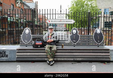 Homme assis sur le célèbre banc Black Sabbath à Birmingham Banque D'Images