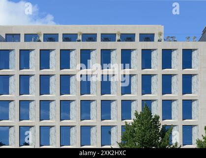 Un immeuble de bureaux moderne avec une façade symétrique avec de grandes fenêtres en verre teinté bleu dans une structure en béton. Le design est minimaliste a Banque D'Images