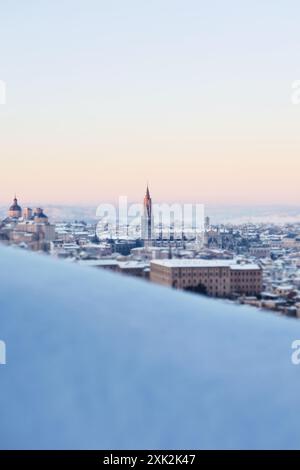 Un matin d'hiver serein à Tolède, en Espagne, alors que la première lumière du lever du soleil illumine le paysage urbain enneigé, mettant en valeur la flèche proéminente du G. Banque D'Images