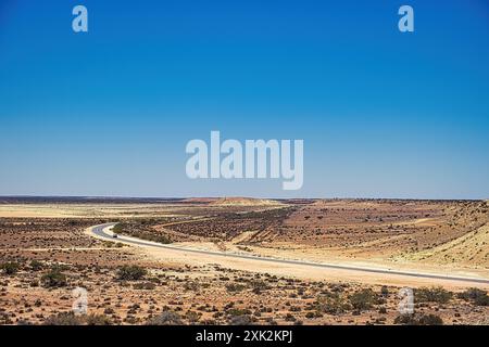 Aérien de route à travers le désert avec de basses collines pierreuses et une végétation clairsemée. North West Coastal Highway, Highway 1, Australie occidentale Banque D'Images