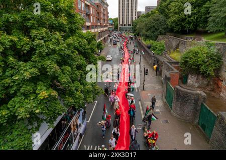 Bristol, Royaume-Uni. 20 juillet 2024. Des centaines de personnes ont transporté un quart de kilomètre de tissu rouge dans les rues du centre de Bristol, pour souligner la guerre contre les habitants de Gaza qui en est maintenant à son neuvième mois. Crédit : Natasha Quarmby/Alamy Live News Banque D'Images