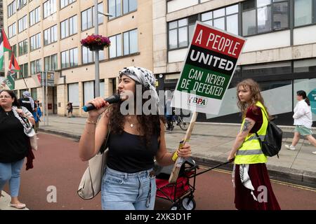 Bristol, Royaume-Uni. 20 juillet 2024. Des centaines de personnes ont transporté un quart de kilomètre de tissu rouge dans les rues du centre de Bristol, pour souligner la guerre contre les habitants de Gaza qui en est maintenant à son neuvième mois. Crédit : Natasha Quarmby/Alamy Live News Banque D'Images