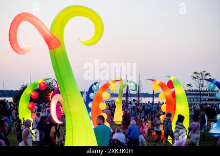 Bad Zwischenahn, Allemagne. 20 juillet 2024. De nombreux visiteurs voient les éléments d'éclairage colorés dans le Kurpark am Zwischenahner Meer pendant la nuit des lumières. Dans le cadre de la nuit des lumières, les jardins du spa de Bad Zwischenahn ont été transformés en une mer de couleurs. Crédit : Hauke-Christian Dittrich/dpa/Alamy Live News Banque D'Images