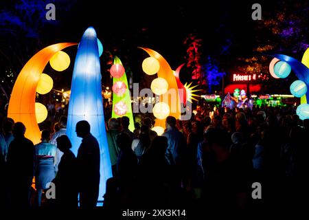 Bad Zwischenahn, Allemagne. 20 juillet 2024. De nombreux visiteurs voient les éléments d'éclairage colorés dans le Kurpark am Zwischenahner Meer pendant la nuit des lumières. Dans le cadre de la nuit des lumières, les jardins du spa de Bad Zwischenahn ont été transformés en une mer de couleurs. Crédit : Hauke-Christian Dittrich/dpa/Alamy Live News Banque D'Images