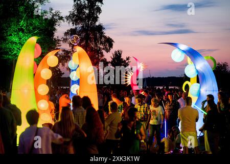 Bad Zwischenahn, Allemagne. 20 juillet 2024. De nombreux visiteurs voient les éléments d'éclairage colorés dans le Kurpark am Zwischenahner Meer pendant la nuit des lumières. Dans le cadre de la nuit des lumières, les jardins du spa de Bad Zwischenahn ont été transformés en une mer de couleurs. Crédit : Hauke-Christian Dittrich/dpa/Alamy Live News Banque D'Images