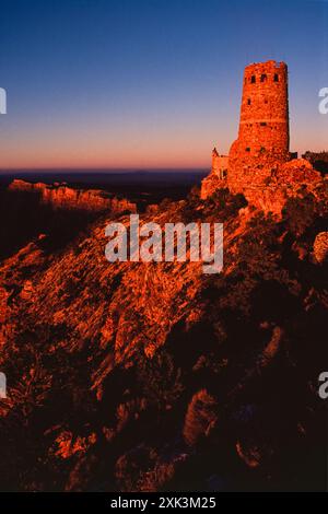 Une vue au coucher du soleil de la tour de guet Desert View, un bâtiment en pierre de 70 pieds de haut, et la zone la plus développée à l'est sur le plateau sud du Grand Canyon dans le parc national du Grand Canyon en Arizona, aux États-Unis. Aussi connue sous le nom de tour de guet indienne à Desert View, elle a été conçue en 1932 par l'architecte Mary Colter. Banque D'Images