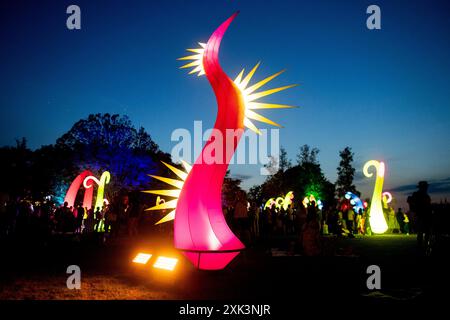 Bad Zwischenahn, Allemagne. 20 juillet 2024. De nombreux visiteurs voient les éléments d'éclairage colorés dans le Kurpark am Zwischenahner Meer pendant la nuit des lumières. Dans le cadre de la nuit des lumières, les jardins du spa de Bad Zwischenahn ont été transformés en une mer de couleurs. Crédit : Hauke-Christian Dittrich/dpa/Alamy Live News Banque D'Images