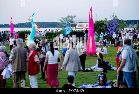 Bad Zwischenahn, Allemagne. 20 juillet 2024. De nombreux visiteurs voient les éléments d'éclairage colorés dans le Kurpark am Zwischenahner Meer pendant la nuit des lumières. Dans le cadre de la nuit des lumières, les jardins du spa de Bad Zwischenahn ont été transformés en une mer de couleurs. Crédit : Hauke-Christian Dittrich/dpa/Alamy Live News Banque D'Images