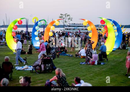 Bad Zwischenahn, Allemagne. 20 juillet 2024. De nombreux visiteurs voient les éléments d'éclairage colorés dans le Kurpark am Zwischenahner Meer pendant la nuit des lumières. Dans le cadre de la nuit des lumières, les jardins du spa de Bad Zwischenahn ont été transformés en une mer de couleurs. Crédit : Hauke-Christian Dittrich/dpa/Alamy Live News Banque D'Images