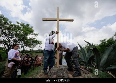 Queretaro, Mexique. 19 juillet 2024. Les membres d'un collectif de recherche célèbrent une cérémonie religieuse. Au cours d’une journée de recherche, le collectif Desaparecidos Querétaro a placé une croix symbolisant la paix sur une propriété de la communauté de Santa Barbara de la Cueva, dans la municipalité de San Juan del Río, Querétaro, où 3 corps ont été trouvés. Ils ont déjà été identifiés. Des canines de la Garde nationale ont également participé à la recherche. Crédit : SOPA images Limited/Alamy Live News Banque D'Images