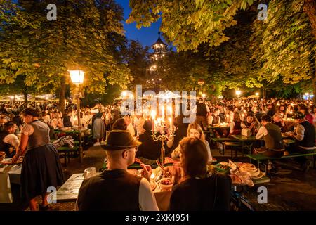 Kocherlball am Chinesischen Turm, Biertrinken BEI Kerzenschein um 4:40 Uhr, München, 21. Juillet 2024 Deutschland, München, 21. Juillet 2024, Biertrinken BEI Kerzenschein um 4:40 Uhr, Kocherlball am Chinesischen Turm,Englischer Garten, Besucher feiern Früh morgens, sitzen schon teilweise ab 4 Uhr Früh im Biergarten, trinken ein Bier, essen eine Brotzeit, tragen Tracht, tradition entstand im 19. Jahrhundert, als HausPersonal, Dienstboten und KöchInnen in den frühen Morgenstunden vor Dienstbeginn gefeiert und getanzt haben, tradition wurde ab 1989 wiederbelebt, traditionell am 3. Sonntag im Juli, feie Banque D'Images