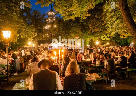 Kocherlball am Chinesischen Turm, Biertrinken BEI Kerzenschein um 4:40 Uhr, München, 21. Juillet 2024 Deutschland, München, 21. Juillet 2024, Biertrinken BEI Kerzenschein um 4:40 Uhr, Kocherlball am Chinesischen Turm, Englischer Garten, Besucher feiern Früh morgens, halb in der Nacht, sitzen schon teilweise ab 4 Uhr Früh im Biergarten, trinken ein Bier, essen eine Brotzeit, tragen Tracht, tradition entstand im 19. Jahrhundert, als HausPersonal, Dienstboten und KöchInnen in den frühen Morgenstunden vor Dienstbeginn gefeiert und getanzt haben, tradition wurde ab 1989 wiederbelebt, traditionell am 3. S Banque D'Images