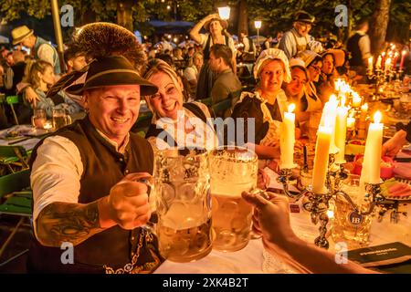 Kocherlball am Chinesischen Turm, Biertrinken BEI Kerzenschein um 5 Uhr, München, 21. Juillet 2024 Deutschland, München, 21. Juillet 2024, Biertrinken BEI Kerzenschein um 5 Uhr, Kocherlball am Chinesischen Turm, Englischer Garten, Besucher feiern Früh morgens, halb in der Nacht, sitzen schon teilweise ab 4 Uhr Früh im Biergarten, trinken ein Bier, essen eine Brotzeit, tragen Tracht, tradition entstand im 19. Jahrhundert, als HausPersonal, Dienstboten und KöchInnen in den frühen Morgenstunden vor Dienstbeginn gefeiert und getanzt haben, tradition wurde ab 1989 wiederbelebt, traditionell am 3. Sonntag Banque D'Images