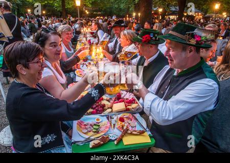 Kocherlball am Chinesischen Turm, Biertrinken BEI Kerzenschein um 5:25 Uhr, München, 21. Juillet 2024 Deutschland, München, 21. Juillet 2024, Biertrinken BEI Kerzenschein um 5:25 Uhr, Kocherlball am Chinesischen Turm, Englischer Garten, Besucher feiern Früh morgens, halb in der Nacht, sitzen schon teilweise ab 4 Uhr Früh im Biergarten, trinken ein Bier, essen eine Brotzeit, tragen Tracht, tradition entstand im 19. Jahrhundert, als HausPersonal, Dienstboten und KöchInnen in den frühen Morgenstunden vor Dienstbeginn gefeiert und getanzt haben, tradition wurde ab 1989 wiederbelebt, traditionell am 3. S Banque D'Images