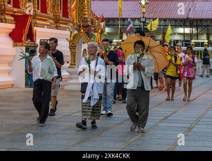 Bangkok, Thaïlande. 20 juillet 2024. Les gens sont vus marcher autour du temple avec des bougies et des fleurs, pendant la cérémonie de la Journée Asalha Puja au temple Wat Thepleela. Aussi connu sous le nom de jour du Dharma, Asalha Puja est l'un des festivals les plus importants du bouddhisme Theravada, célébrant le premier sermon de Bouddha. La journée est considérée comme une occasion pour les bouddhistes de montrer leur gratitude en faisant des offrandes aux temples et en écoutant des sermons. Crédit : SOPA images Limited/Alamy Live News Banque D'Images