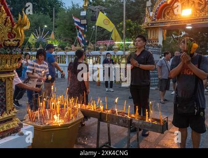 Bangkok, Thaïlande. 20 juillet 2024. Les gens sont vus prier et apporter des bougies allumées pendant la cérémonie de la Journée Asalha Puja au temple Wat Thepleela. Aussi connu sous le nom de jour du Dharma, Asalha Puja est l'un des festivals les plus importants du bouddhisme Theravada, célébrant le premier sermon de Bouddha. La journée est considérée comme une occasion pour les bouddhistes de montrer leur gratitude en faisant des offrandes aux temples et en écoutant des sermons. Crédit : SOPA images Limited/Alamy Live News Banque D'Images