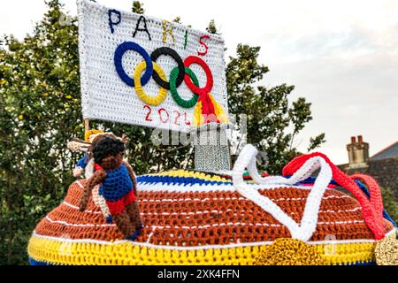 Topper de boîte aux lettres tricoté coloré célébrant les Jeux Olympiques de Paris 2024 avec médailles crochetées, athlètes, flamme et anneaux olympiques, Weymouth, Dorset Banque D'Images