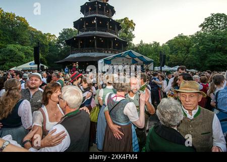 Kocherlball am Chinesischen Turm, hunderte Paare tanzen zur bayerischen Musik, morgens um 6:15 Uhr, München, 21. Juillet 2024 Deutschland, München, 21. Juli 2024, hunderte Paare tanzen zur bayerischen Musik, morgens um 6,15 Uhr, eine Stunde nach Sonnenaufgang, Kocherlball am Chinesischen Turm, Englischer Garten, Musikapelle Quetschnblech spielt auf, Besucher feiern und tanzen Früh morgens zu bayerischer Musik, tragen Tracht, tradition entstand im 19. Jahrhundert, als HausPersonal, Dienstboten und KöchInnen in den frühen Morgenstunden vor Dienstbeginn gefeiert und getanzt haben, tradition wurde a Banque D'Images