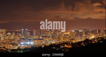 Paysage urbain, nuit et lumières avec ville, bâtiments et destination touristique ou de vacances populaire à Waikiki honolulu. Voyages de luxe, gratte-ciel et Banque D'Images