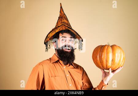 Autocollants Happy Halloween. Beau Halloween homme avec citrouille à la main. Homme barbu cuisez dans un chapeau d'Halloween avec de la citrouille. Célébration de Thanksgiving heureux Banque D'Images